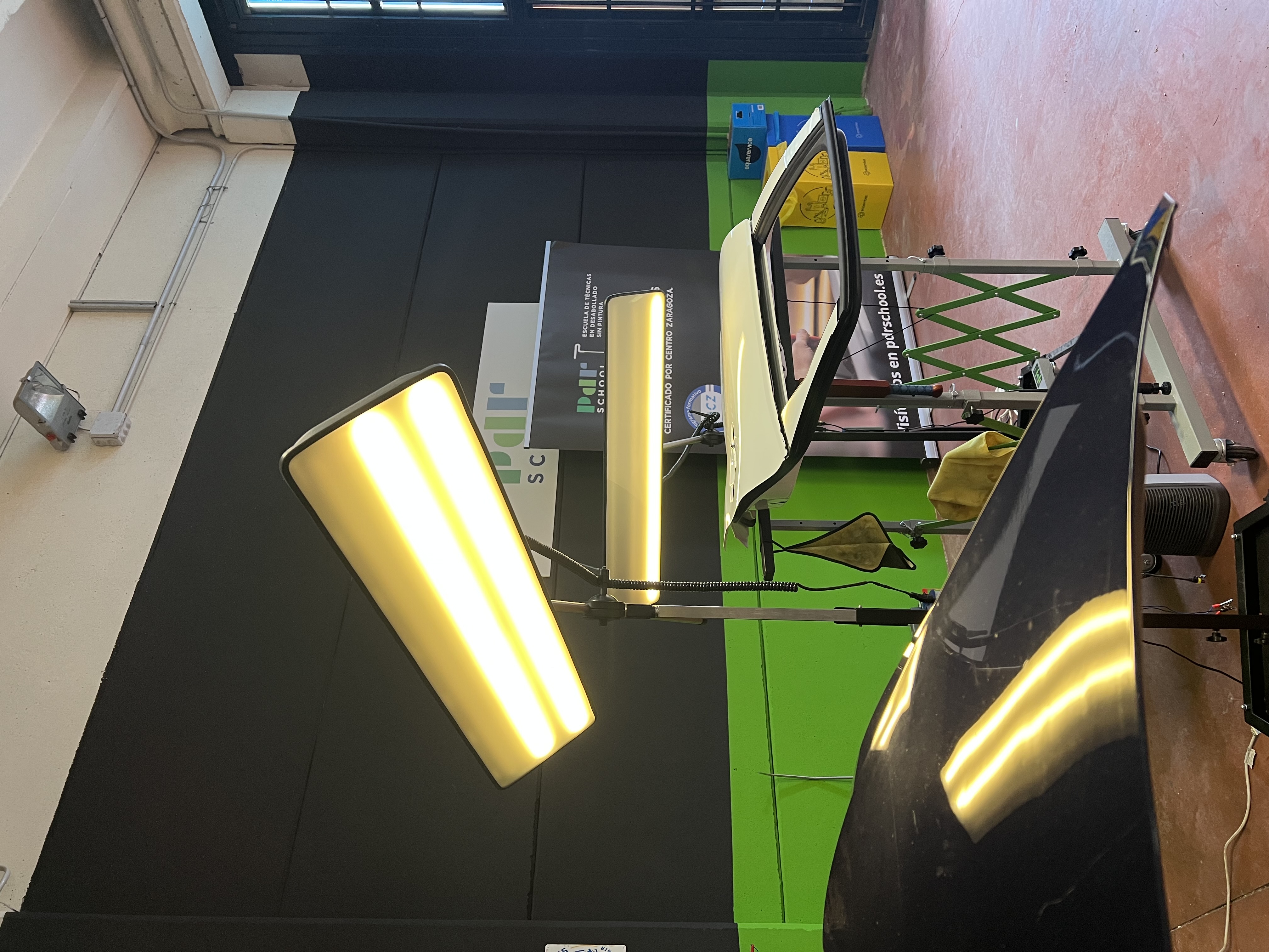 Aula de PDR School con lámparas de reflejo y paneles de coche preparados para prácticas